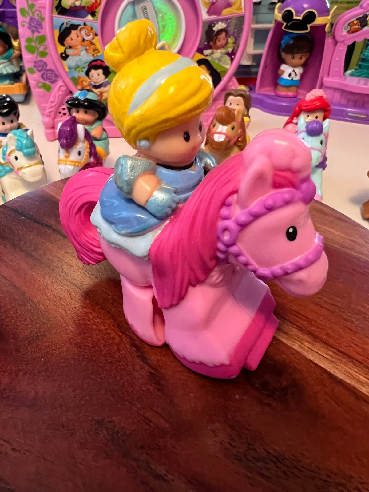 Little People rider figure with yellow hair on pink horse, side view
