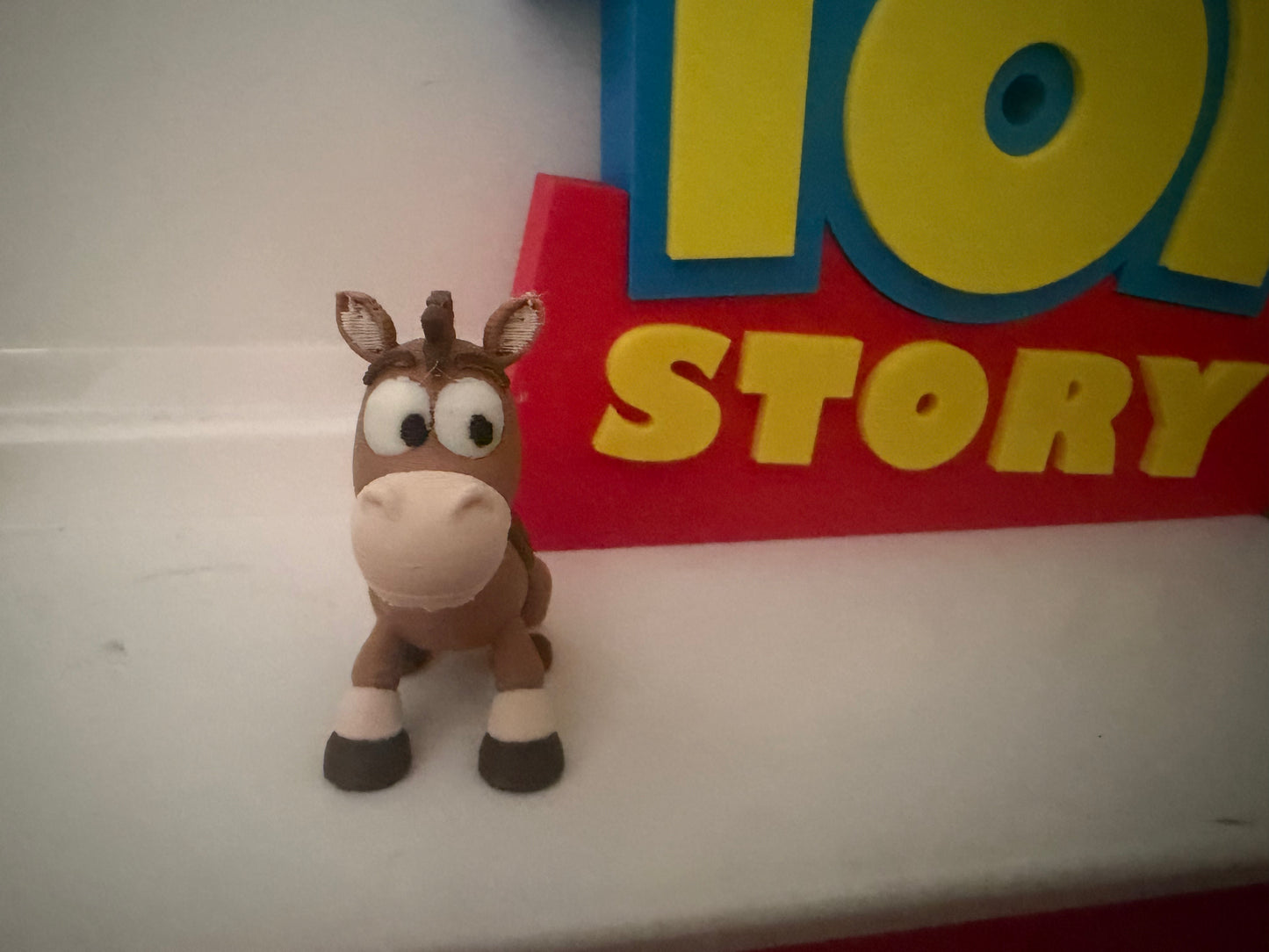Small collectible toy figure: brown horse character with white muzzle and big eyes