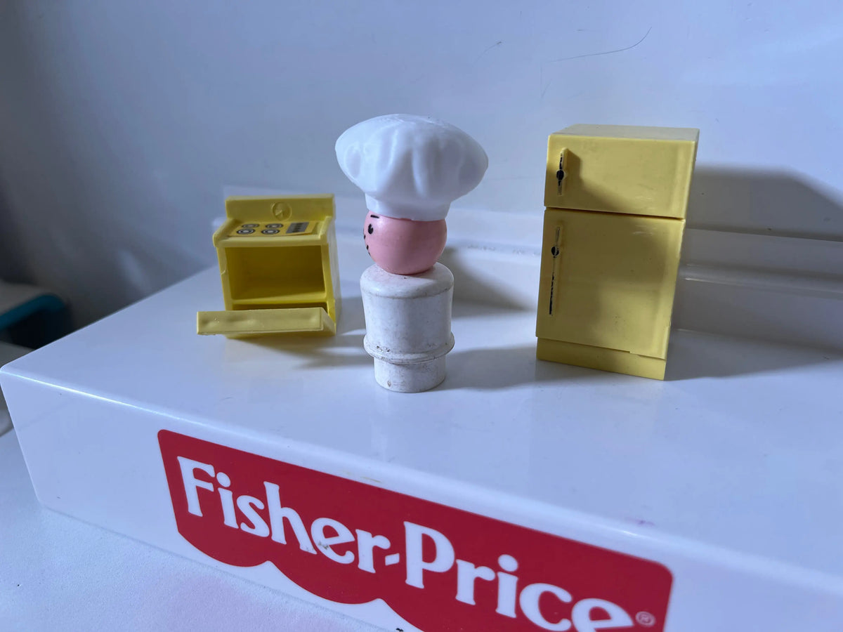 Miniature chef hat on small figure, side profile with white hat and light torso