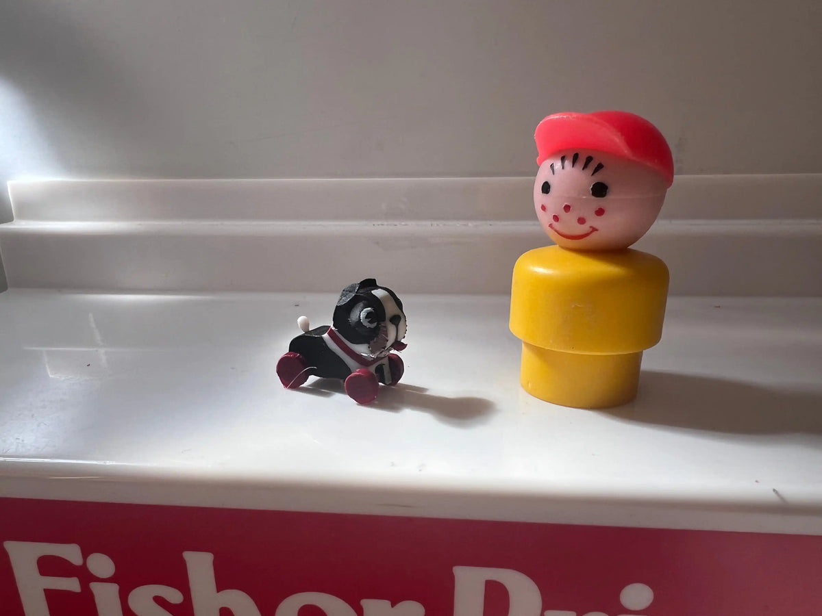 Mini barking dog and child figure, red-capped head on yellow body inside red Fisher-Price box