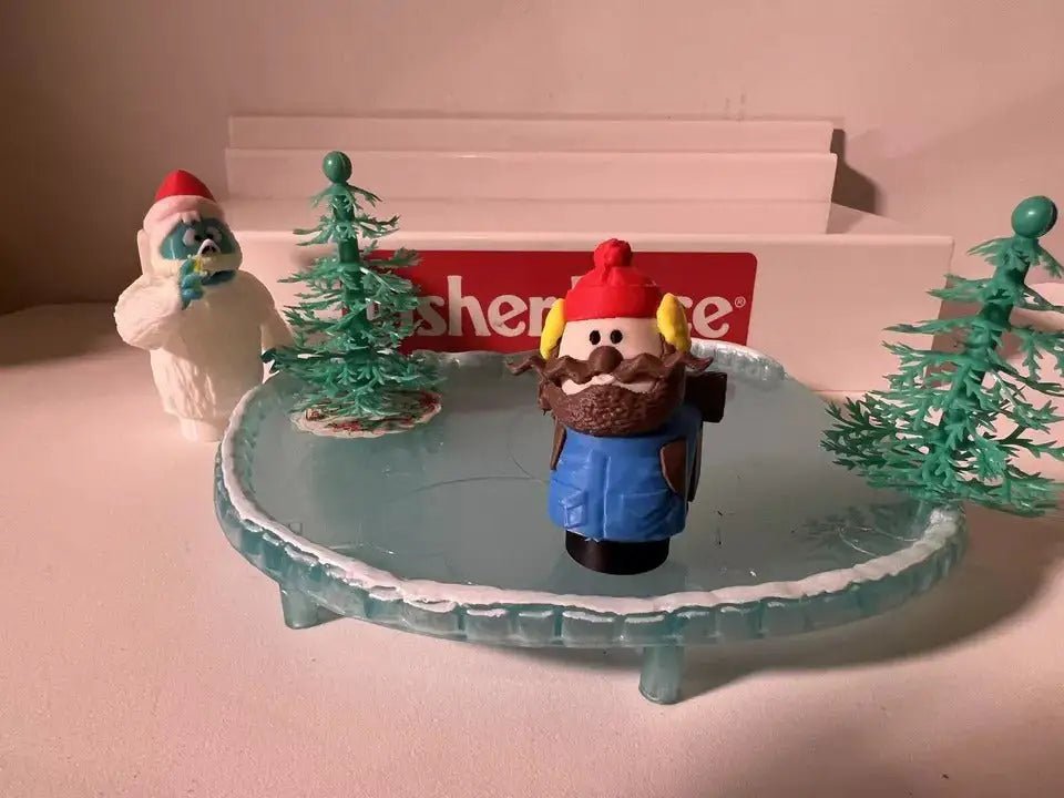 Christmas holiday figurine set with nutcracker-style character and elf figure on icy base and trees
