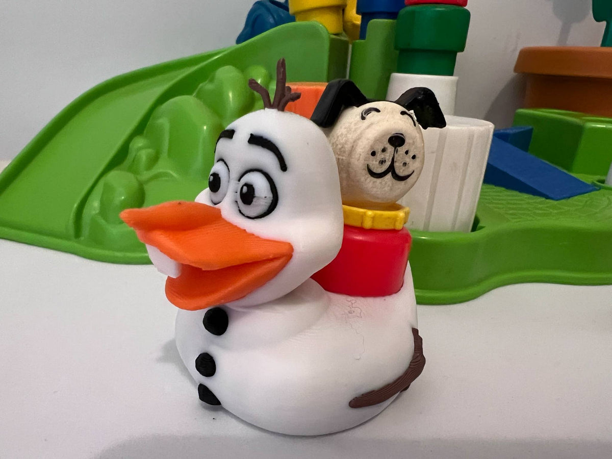White duck and dog stack toy figures on green play tray