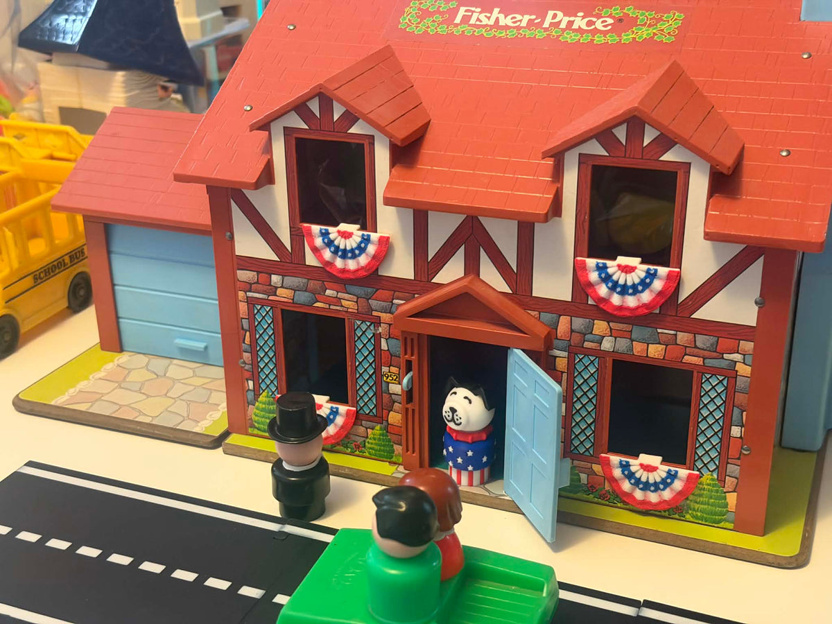 Mini American bunting flags decorating a dollhouse exterior above the windows