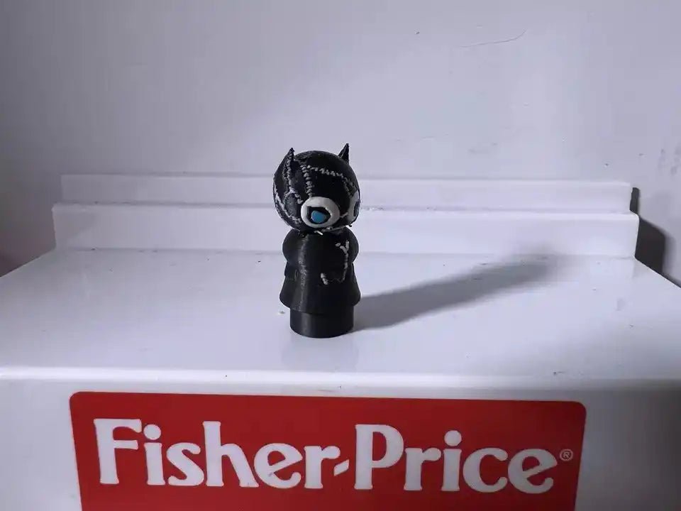 Black cat character figurine with blue eyes, pointed ears, standing on a small base