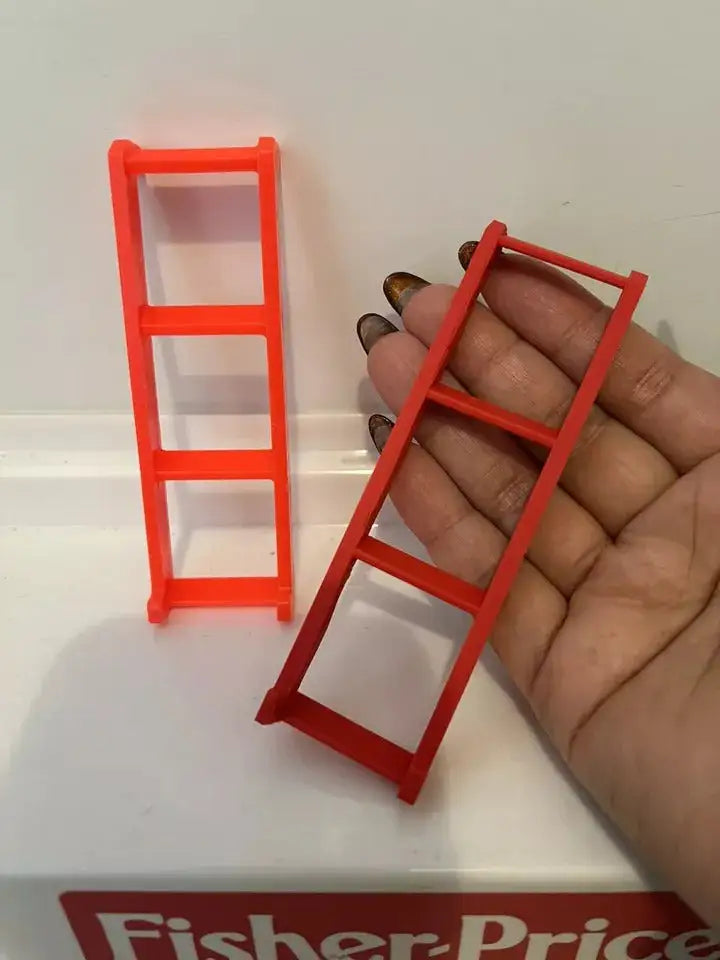 A hand holds a custom red 3D-printed replacement ladder for a Fisher-Price Little People #994 Camper, next to an original.