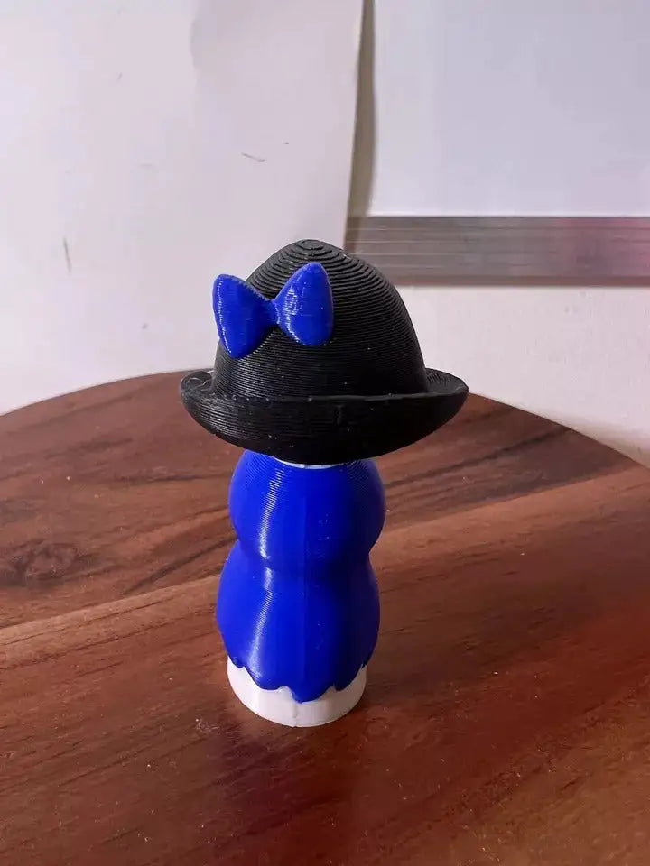 Betty doll figurine back view, blue dress and black bonnet with blue bow
