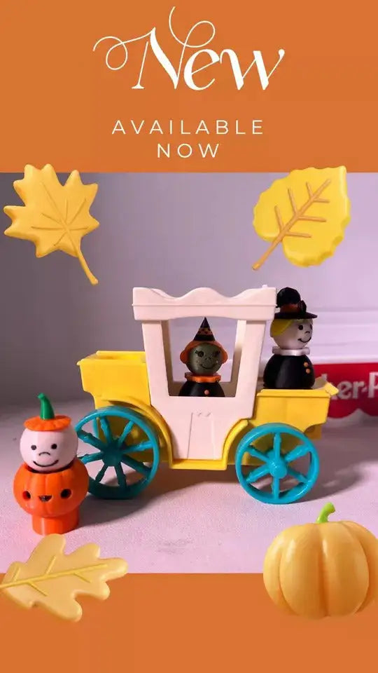 Halloween pumpkin boy figurine beside yellow toy wagon with blue wheels