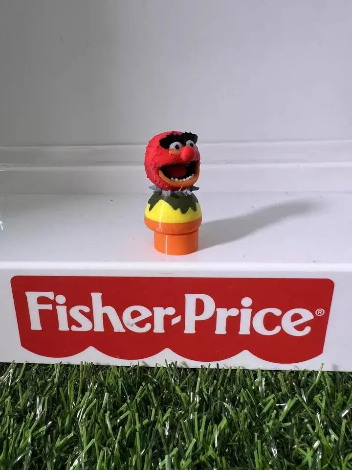 Plush animal figure with red head and open mouth, yellow top and orange base