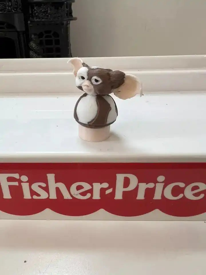 Brown-and-white dog figurine with big ears on round beige base