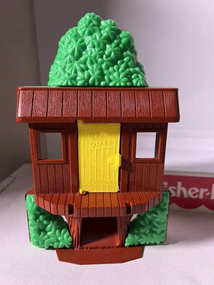 Brown toy tree house door with yellow panel and green tree detail