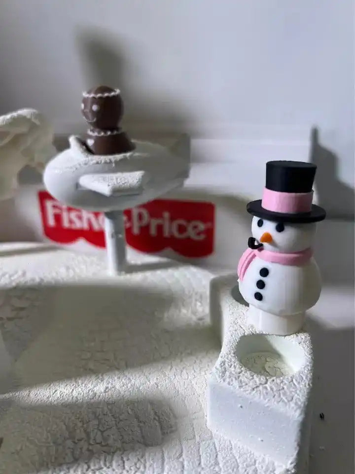Snowman figurine with black top hat and candy-striped details on white snowy base