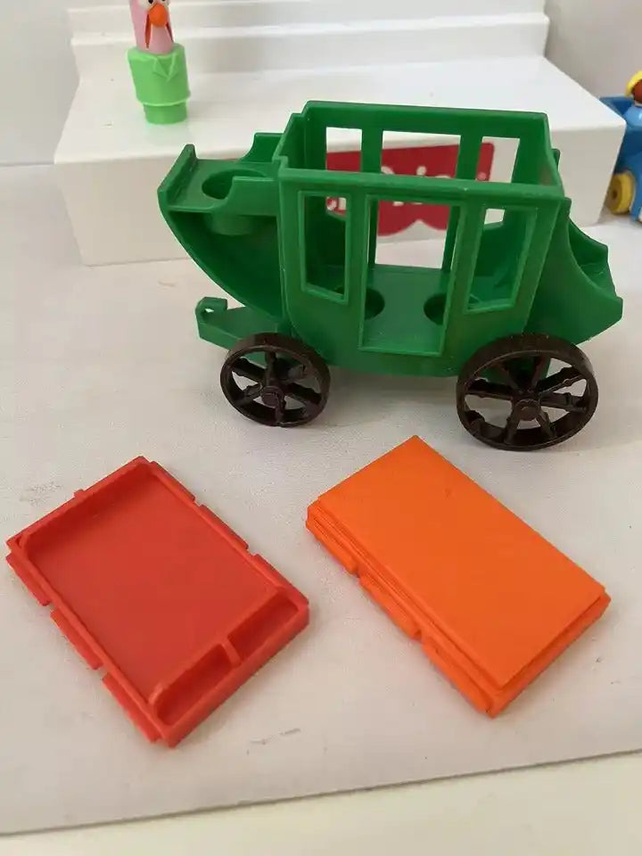 A green Fisher-Price Little People #934 Western Stagecoach with two red and orange replacement roofs next to it.