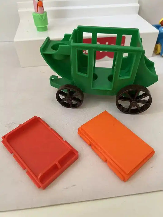 A green Fisher-Price Little People #934 Western Stagecoach with two red and orange replacement roofs next to it.