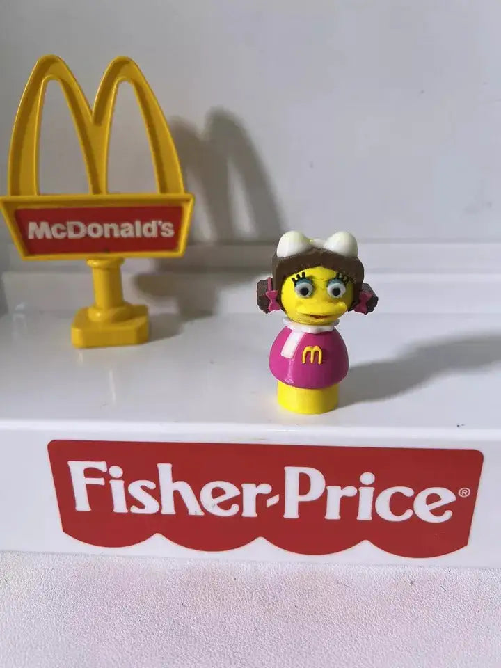 A custom 3D printed Fisher-Price Little People-style McDonald's Birdie figure stands next to a McDonald's sign.