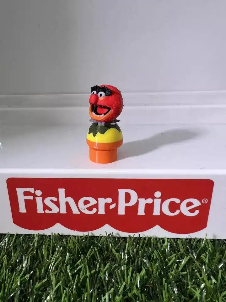 Plush animal figure with red head and open mouth, yellow top on orange base