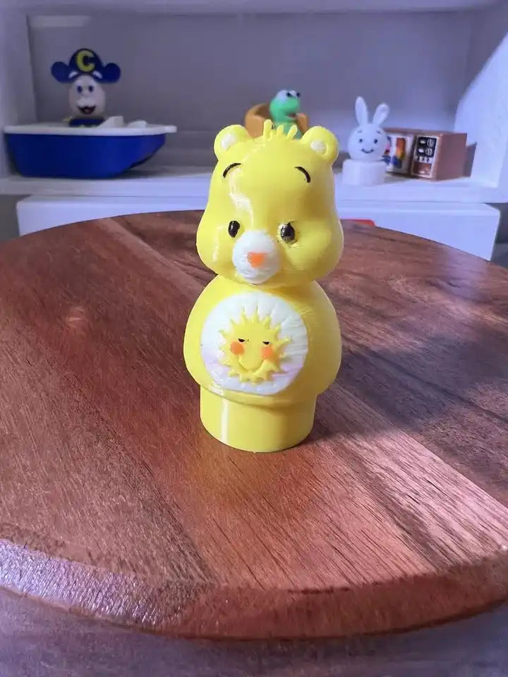 Yellow bear figurine with smiling face and sun emblem on belly