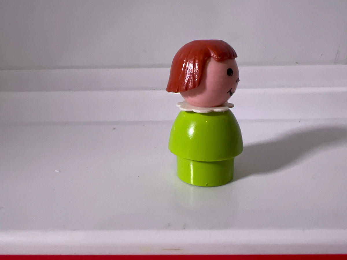 Lime green girl figure with red bob hair, turned side view