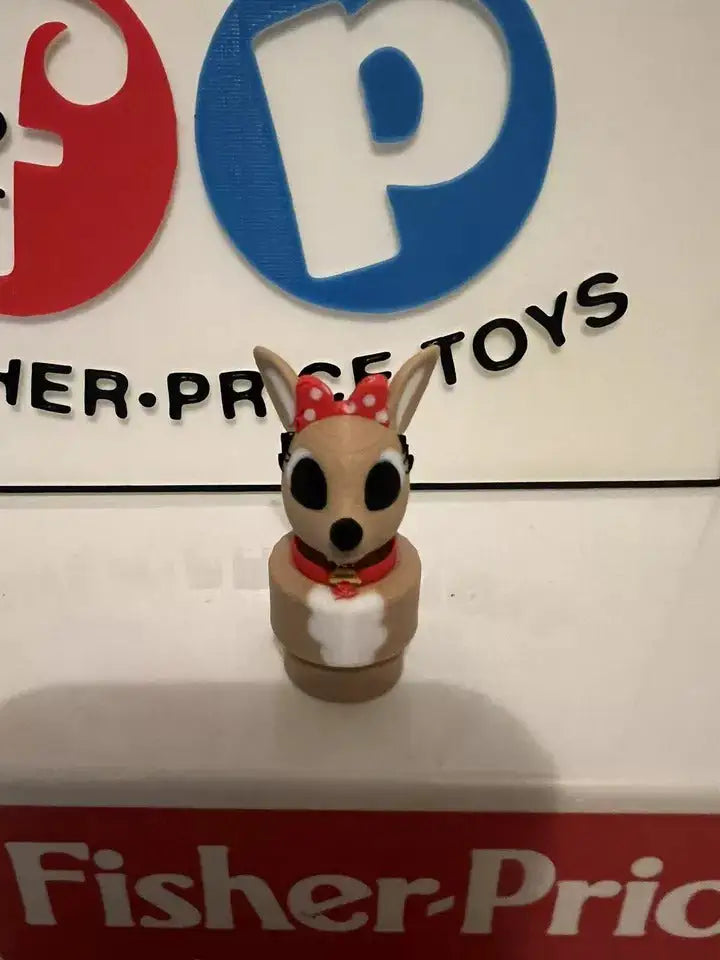Small animal holiday figurine with red scarf and red polka-dot bow, facing forward.