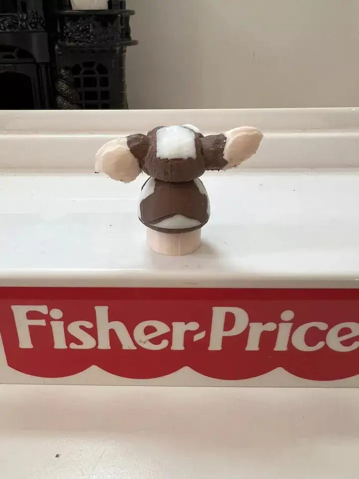 Rear view of brown-and-white dog figurine on round beige base