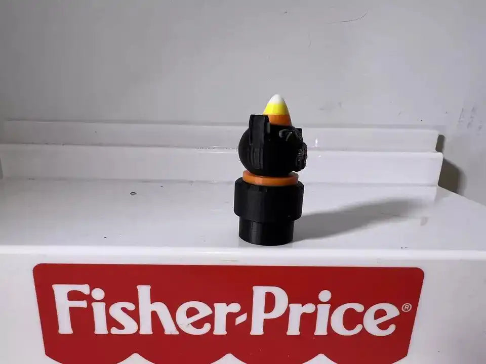 Black cat figurine with pointed yellow-and-purple wizard hat