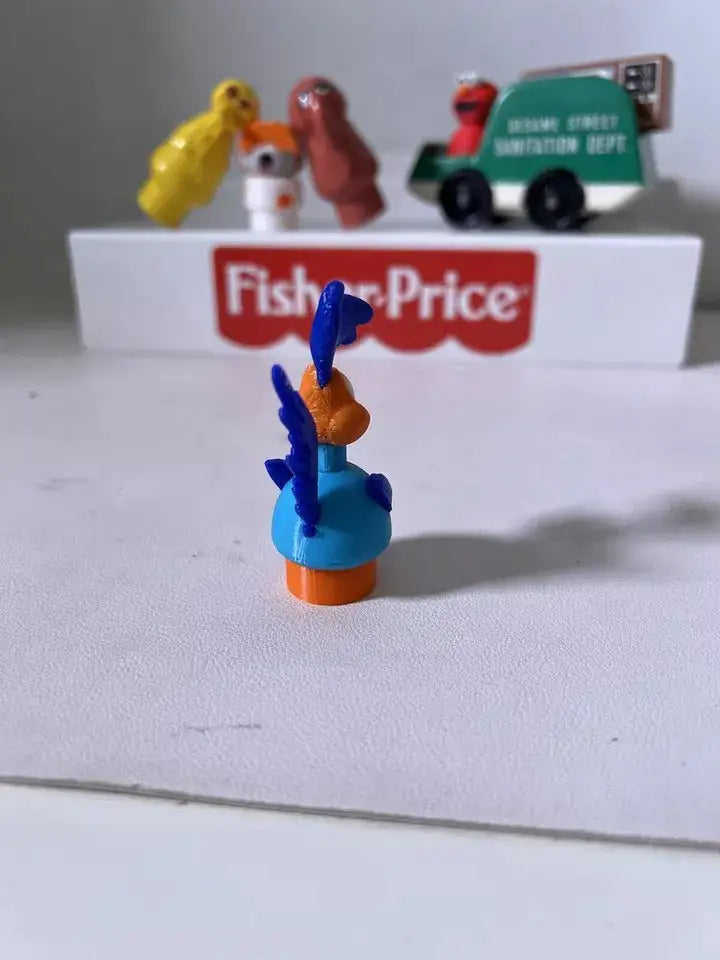 Road Runner-style plastic figure in blue with orange base, blue wings raised