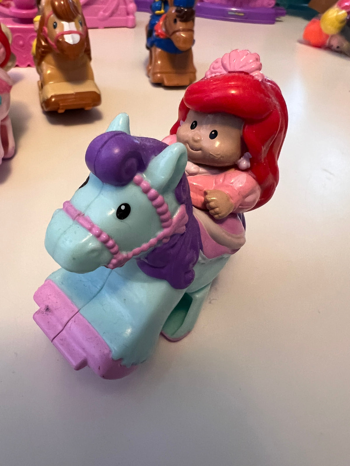 Little People rider figure with red hair on light teal horse, molded toy