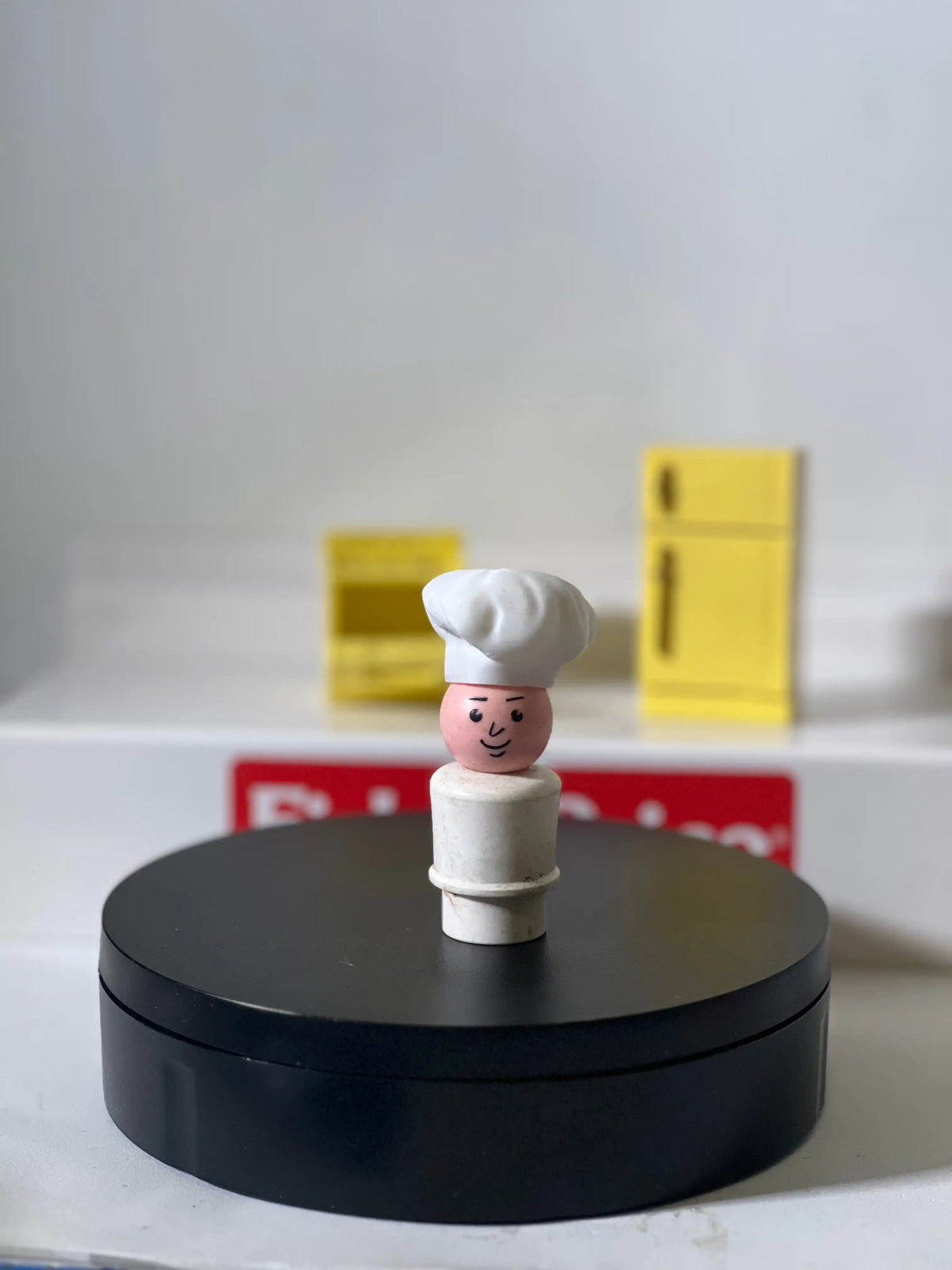 Miniature chef hat accessory: small chef figure with white hat on pedestal