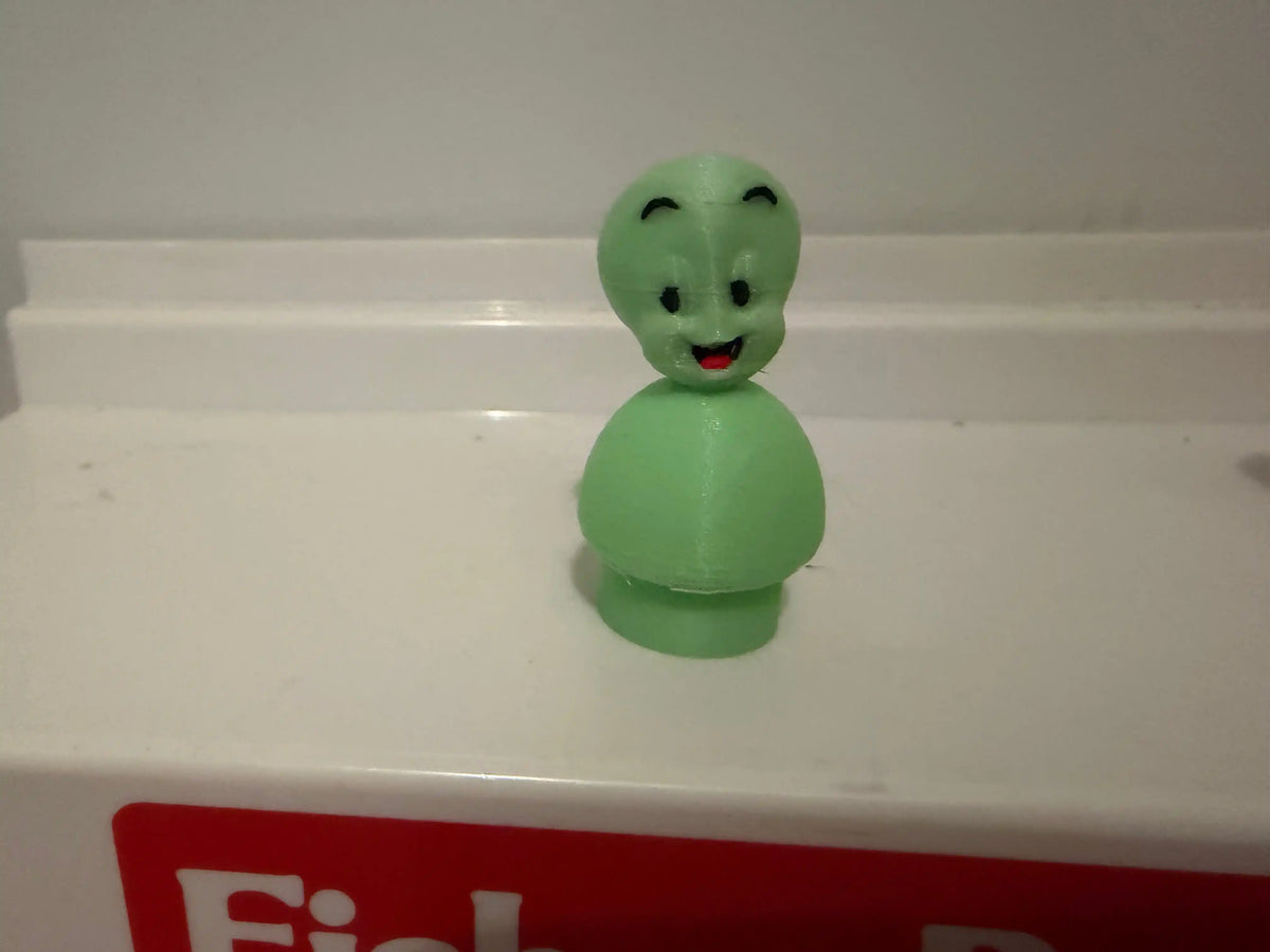 Glow-style green Casper the Friendly Ghost figurine with black eyes and red lips.