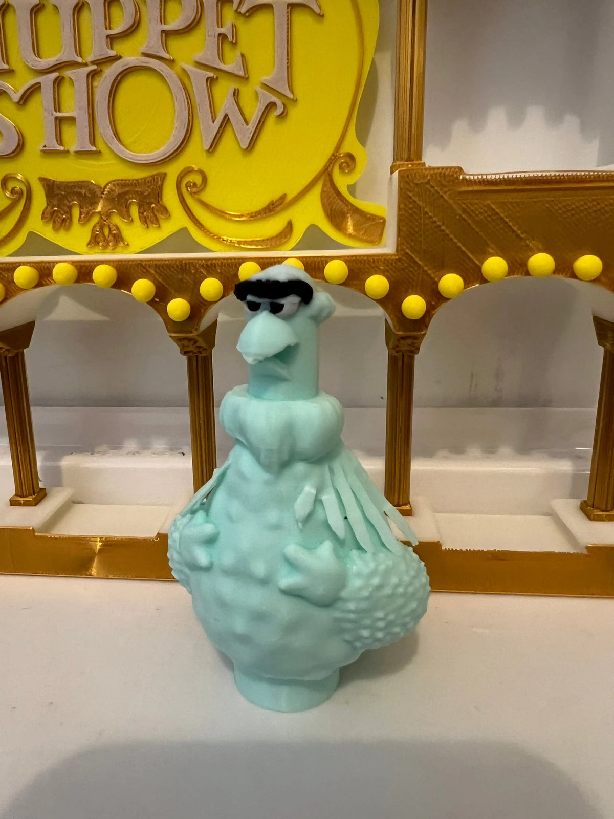 Turquoise plush eagle figurine with black tuft, shown from the front