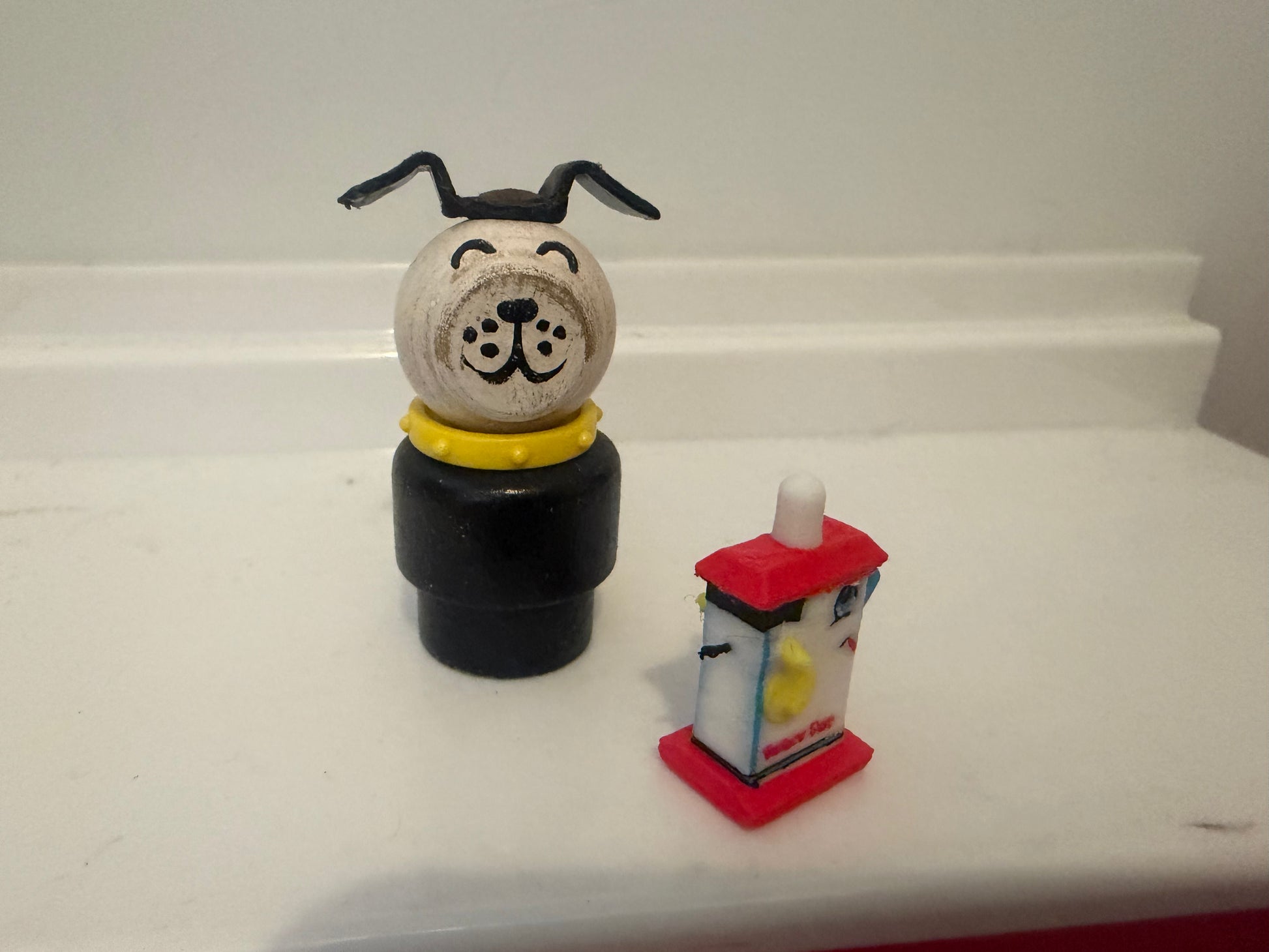Miniature dog figurine on black base with small red lantern display piece