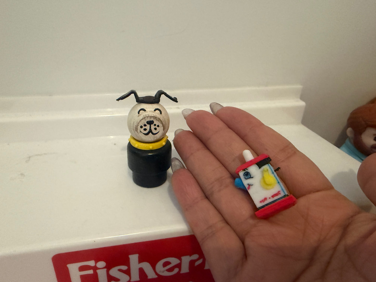 Miniature dog figurine on black base with small red lantern accessory in hand