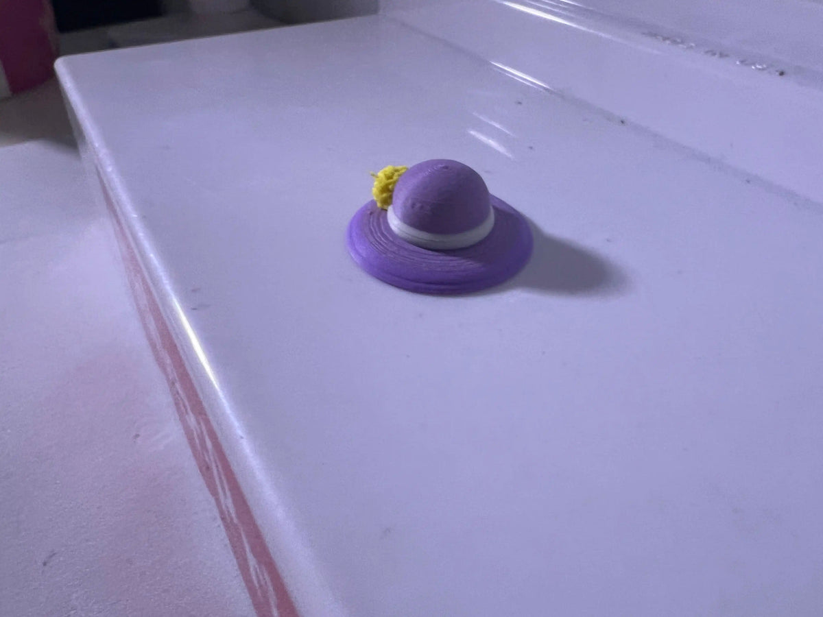 Purple summer hat with small yellow flower on a wide brim