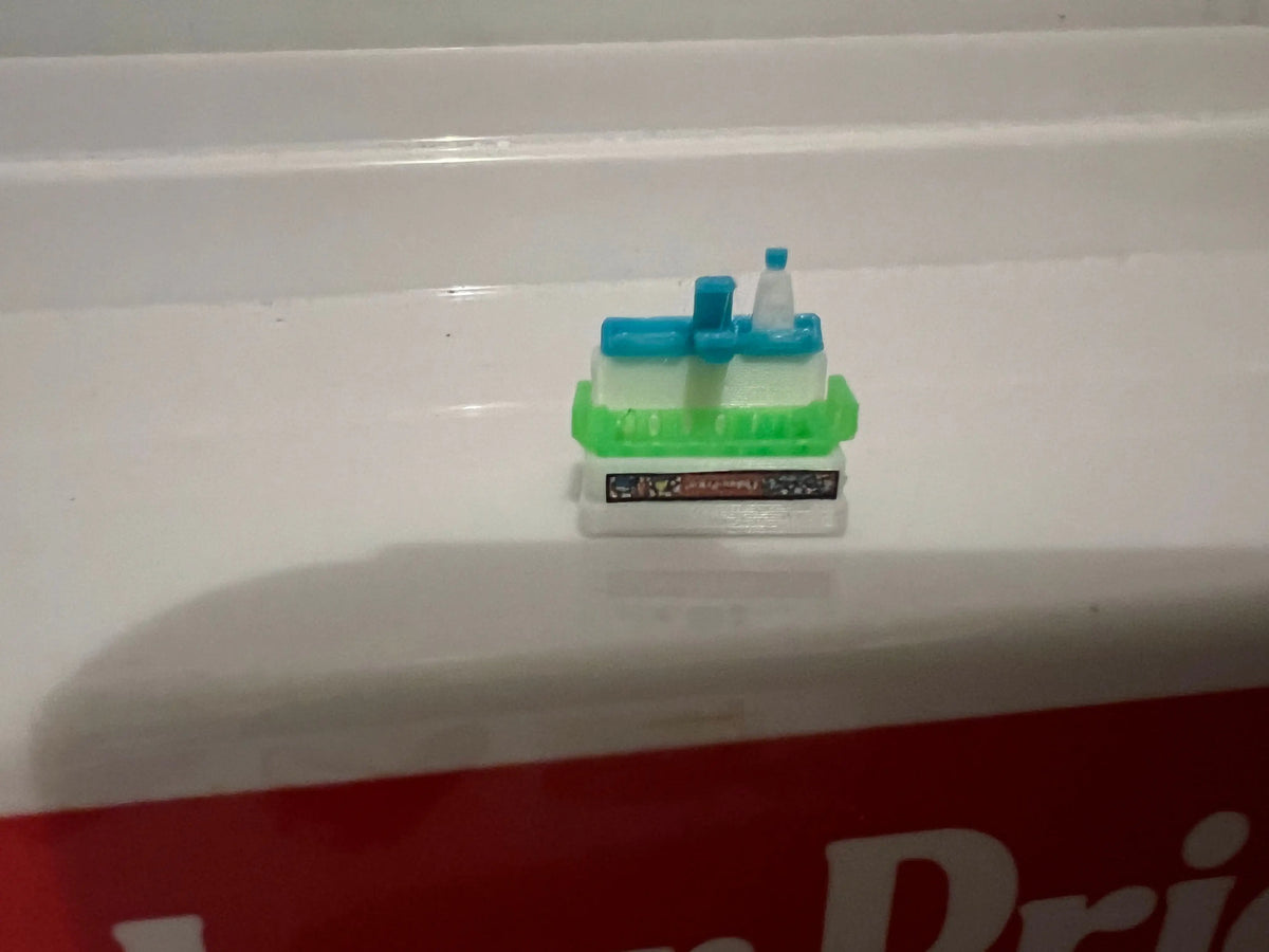 Miniature retro playset sink with blue faucet and green counter, small base tray