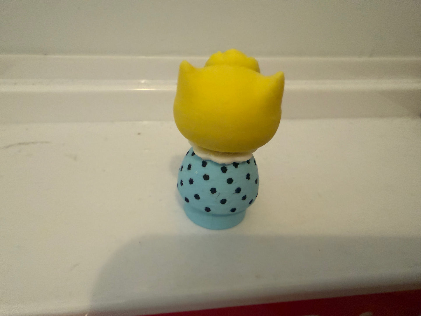 Sally Brown style 3D figure from behind with yellow hair and blue polka-dot dress