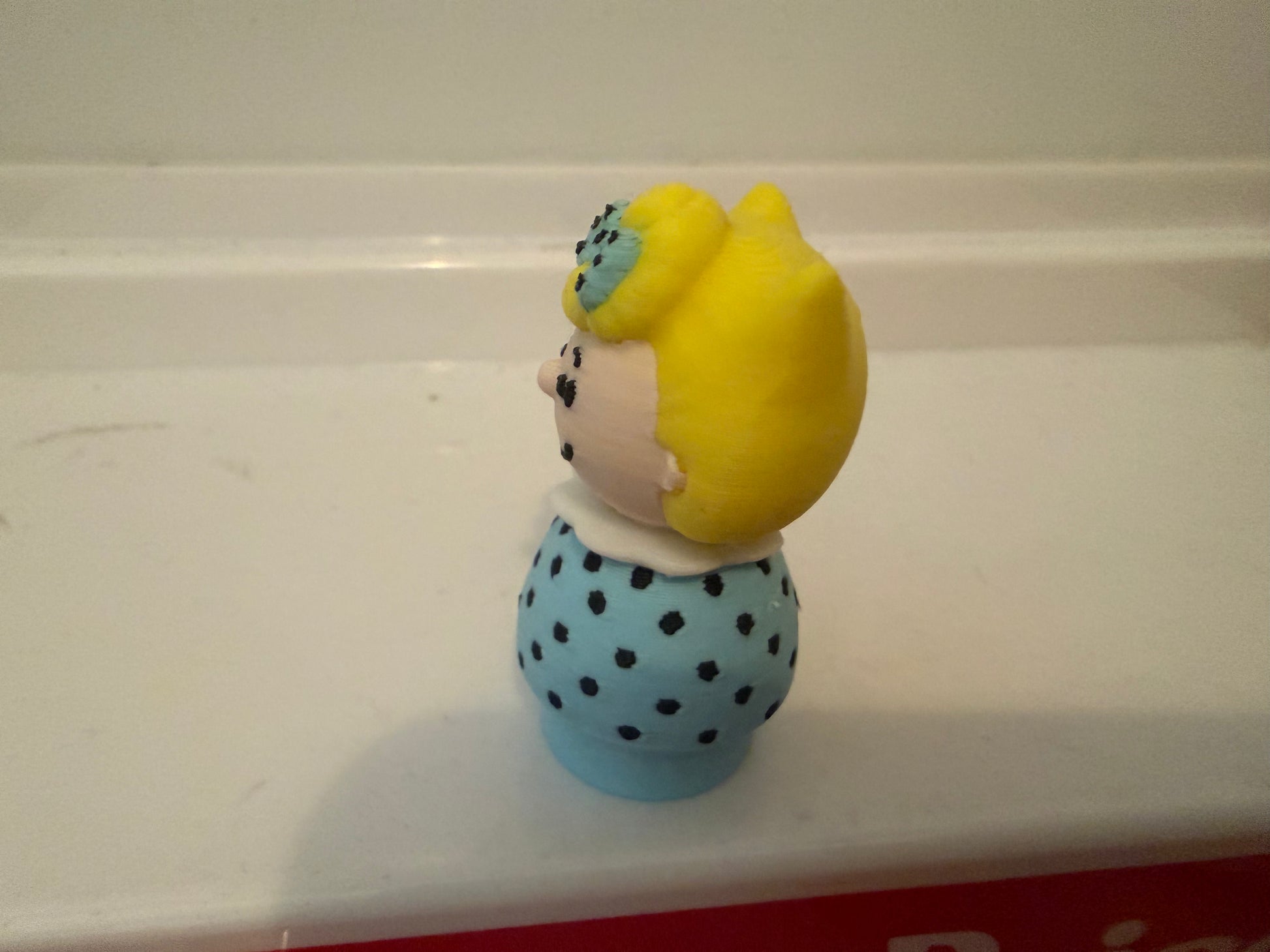 Sally Brown style 3D figure with yellow hair pulled back and blue polka-dot dress