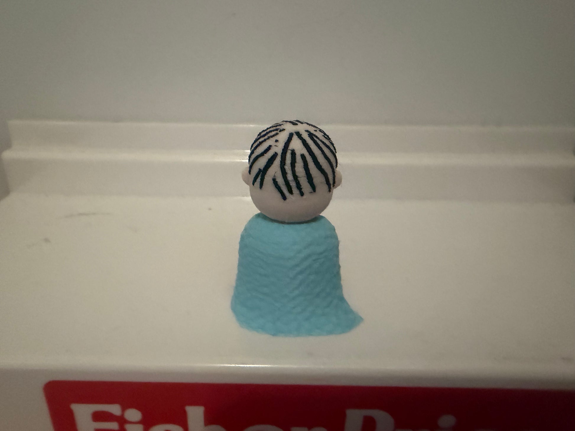 3D Linus collectible figure from behind, blue blanket and striped shirt