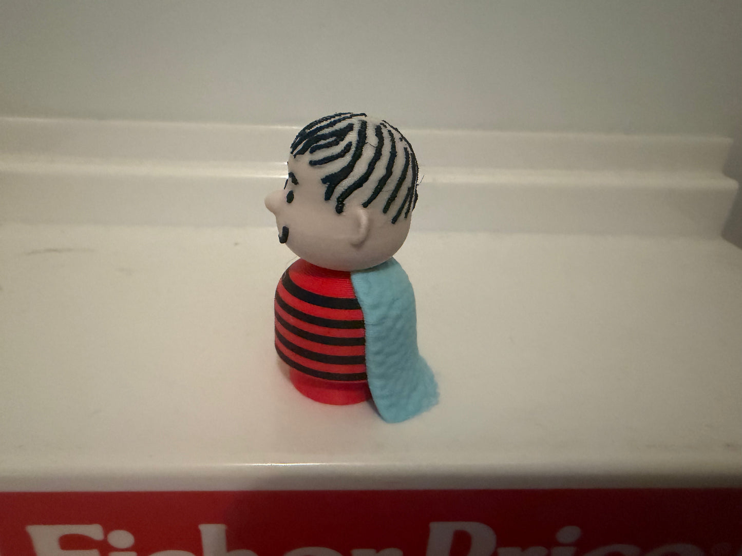3D Linus collectible figure side profile, red striped shirt and blue blanket