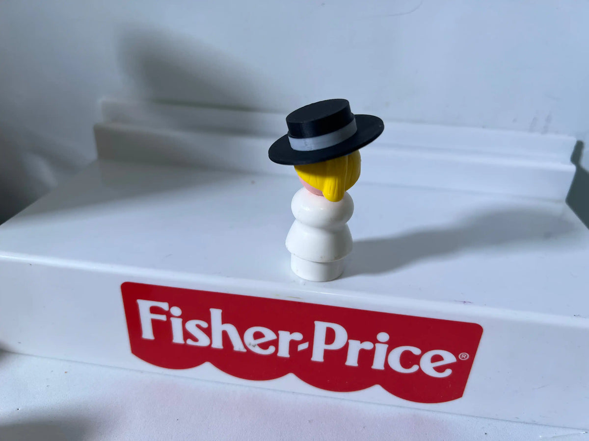 Vintage Fisher-Price figure wearing a black top hat with yellow hair, red logo below