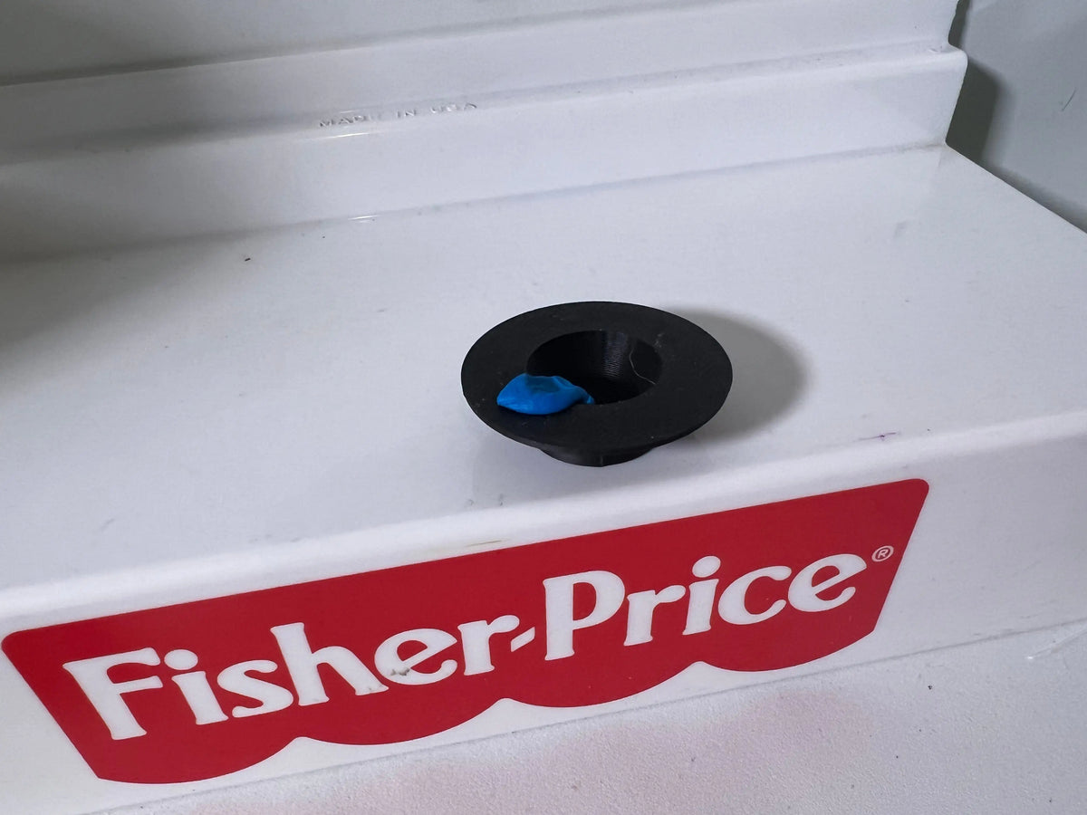 Black top hat underside with small blue detail on white base, Fisher-Price label below