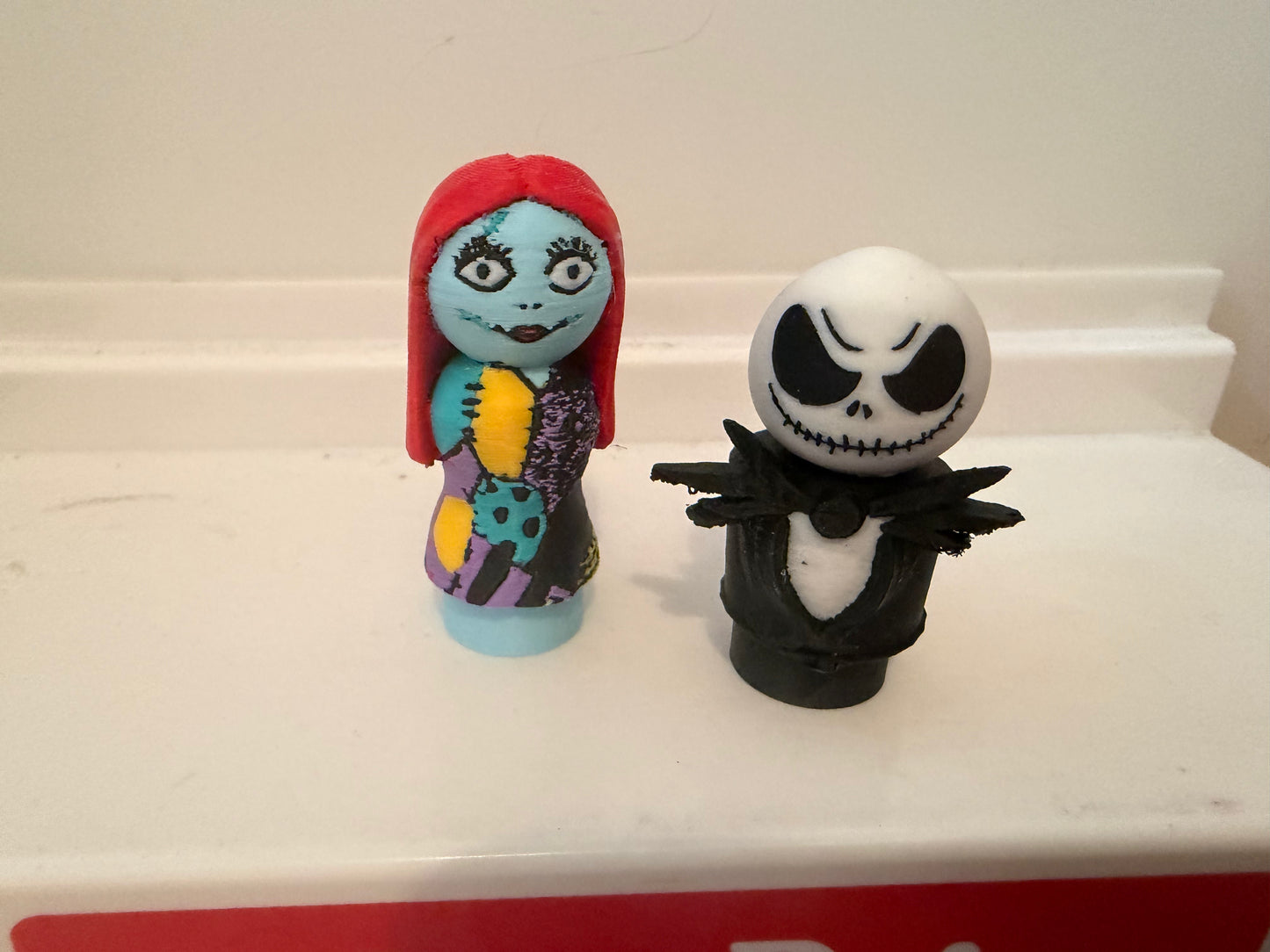 Sally and Jack collectible figures: Sally in red hood, Jack in black outfit