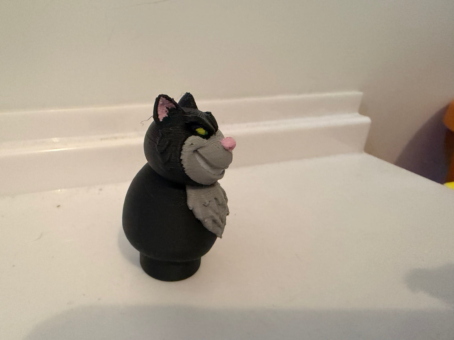 Lucifer black cat villain figure side view with gray belly and raised paw