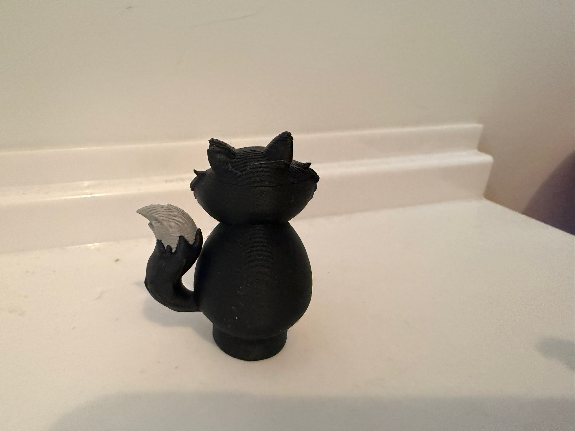 Lucifer black cat villain figure back view with gray winged tunic