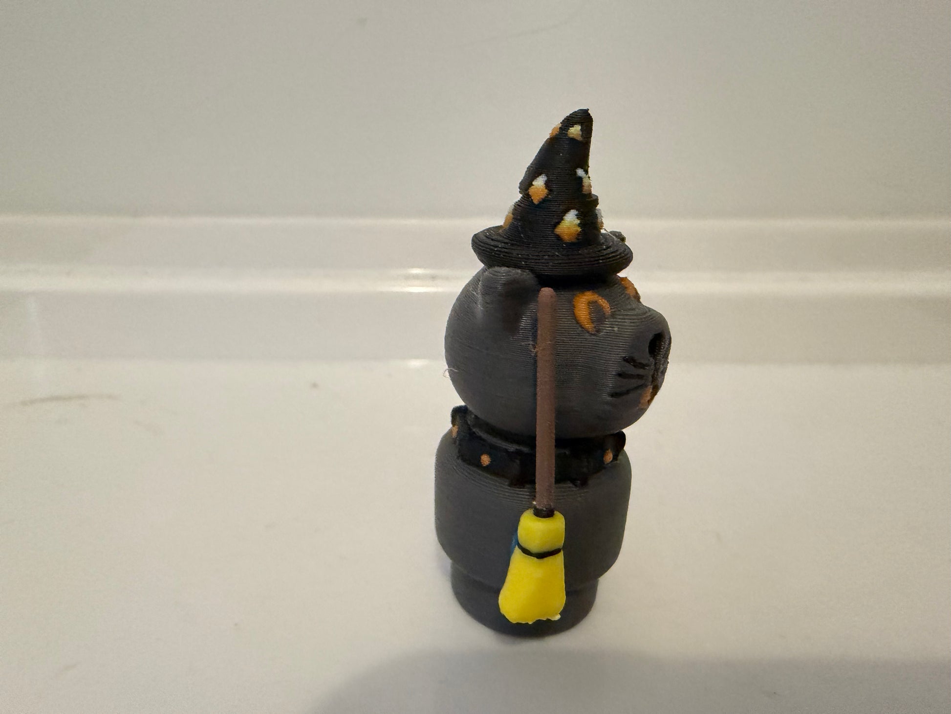 Halloween sorcerer cat figure with black witch hat, gray cat body, and vertical wand/staff