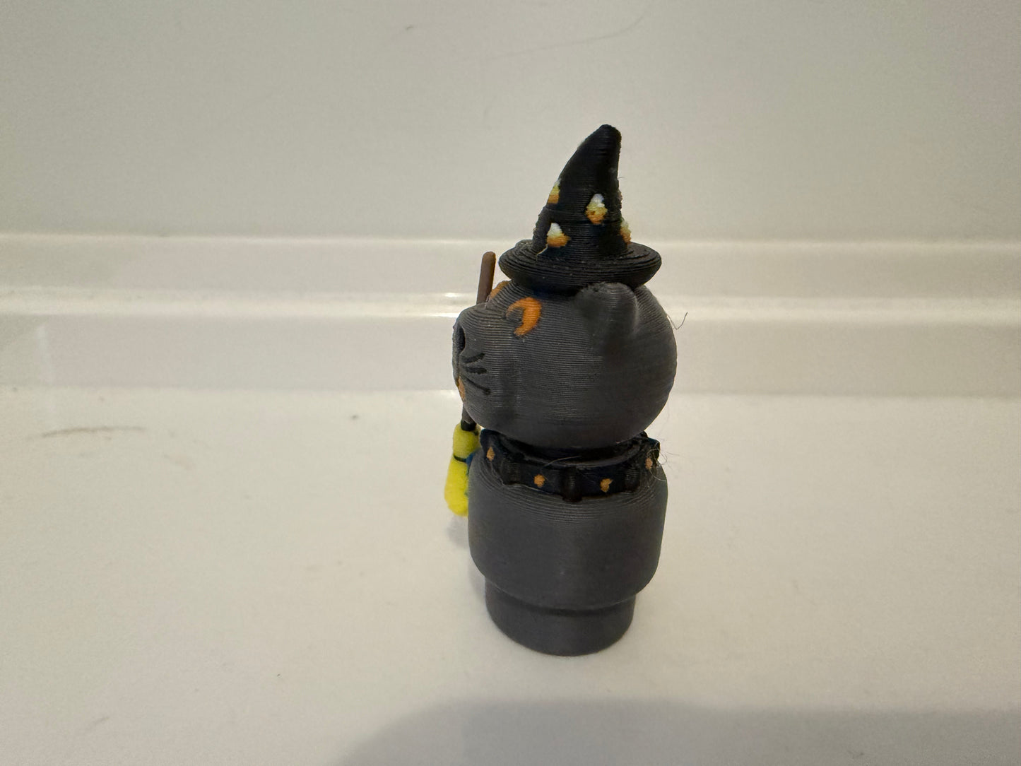 Halloween sorcerer cat figure facing front-left with black witch hat and gray outfit details