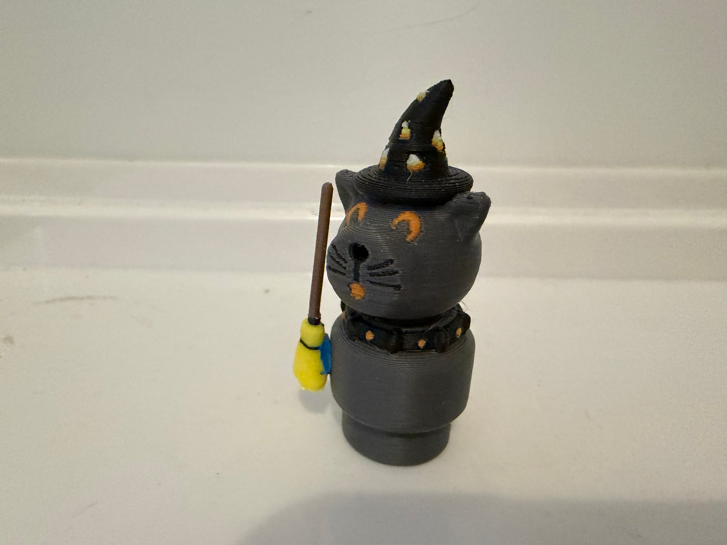 Halloween sorcerer cat figurine with black witch hat, gray face, and wand/staff accessory