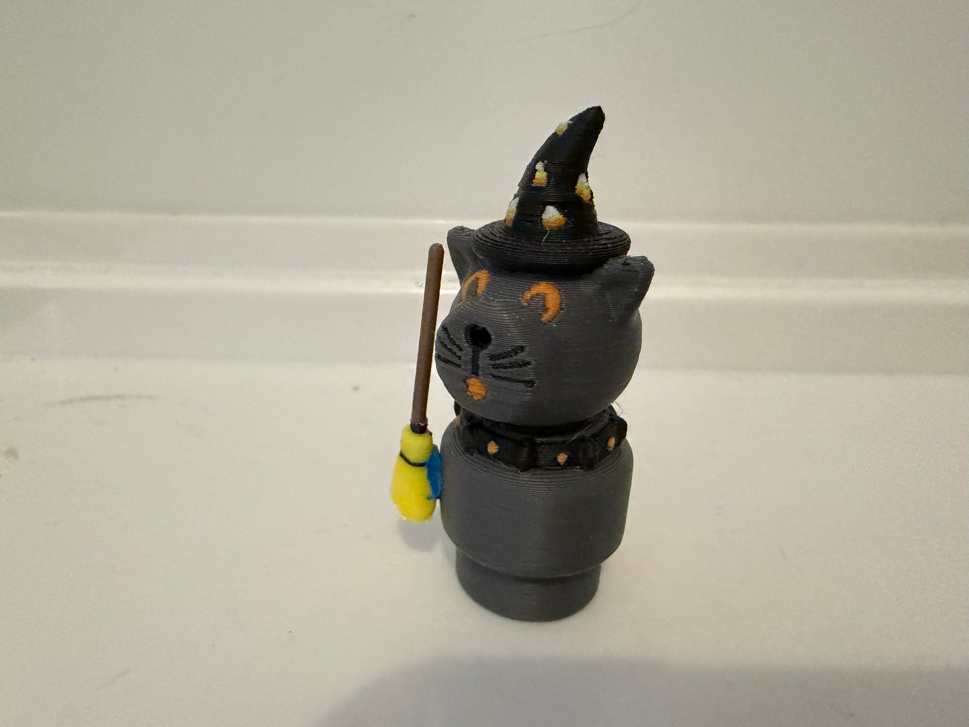 Halloween sorcerer cat figurine with black witch hat, gray face, and wand/staff accessory