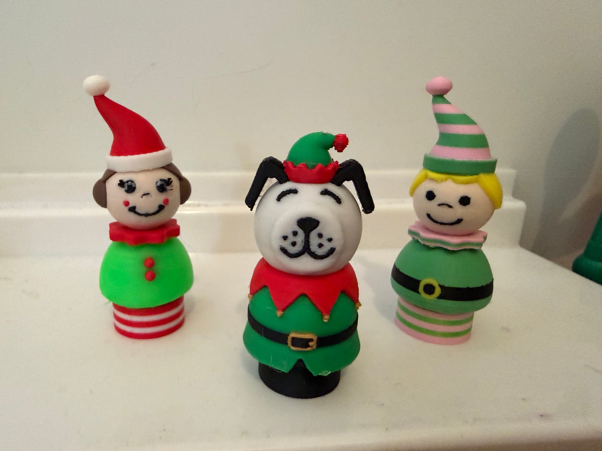 Set of three holiday figurines: dog elf, red-striped elf, and green-striped cat