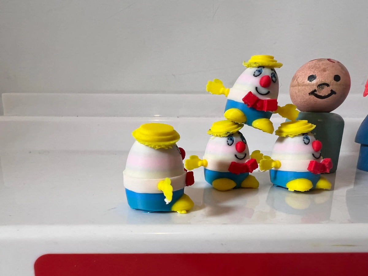 Miniature figurines with egg heads, yellow hats, blue overalls, yellow shoes and smiles.