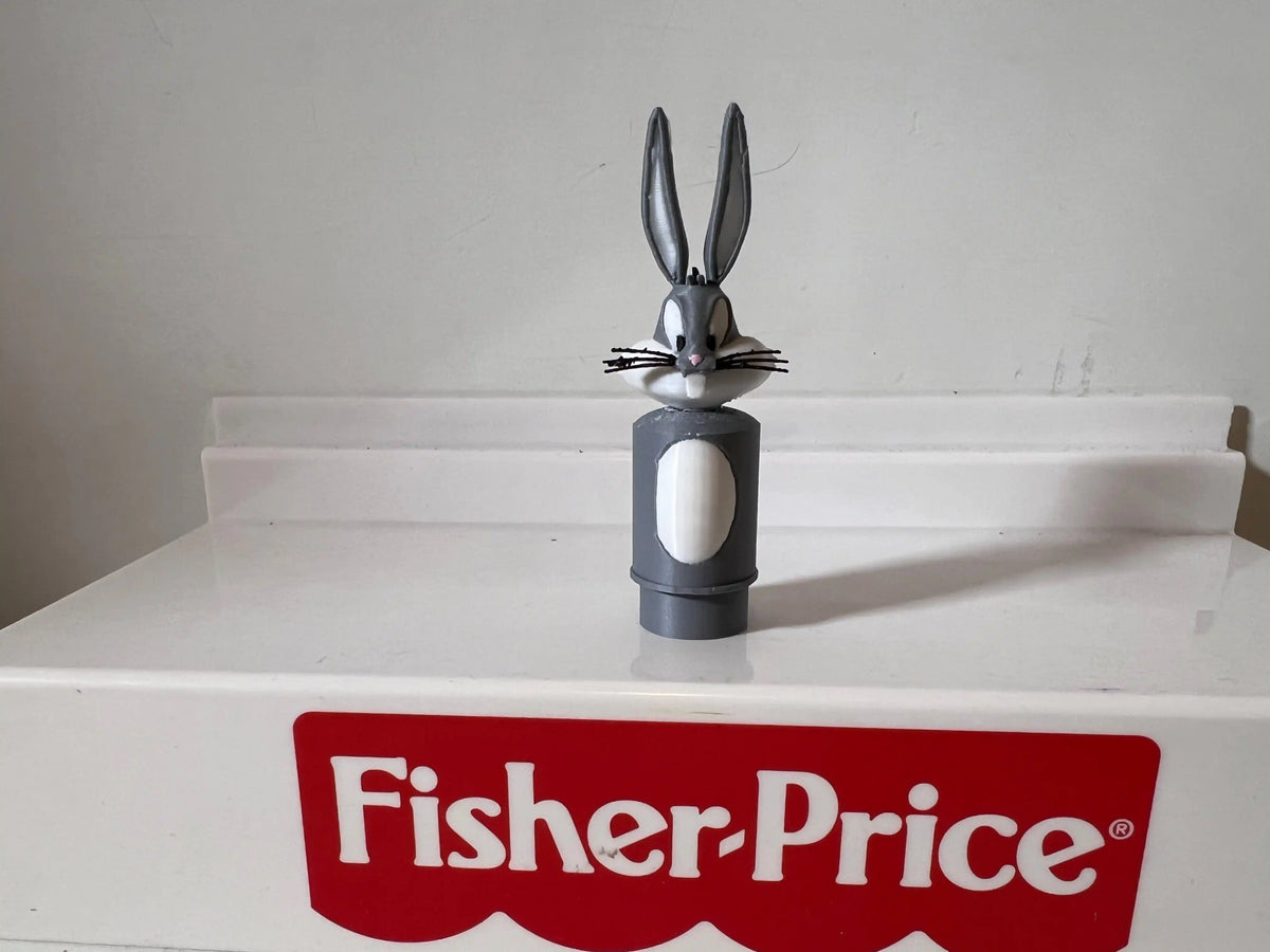 Gray Bugs Bunny figurine on top of a white Fisher-Price branded box