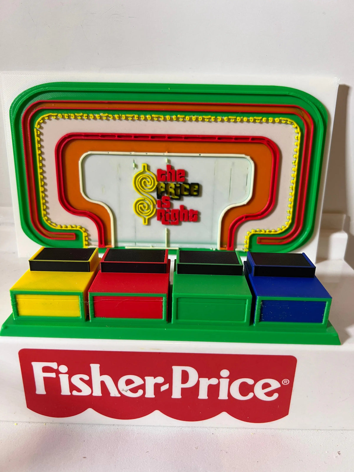 Game show backdrop and contestant row set with colored podium blocks and Fisher-Price logo